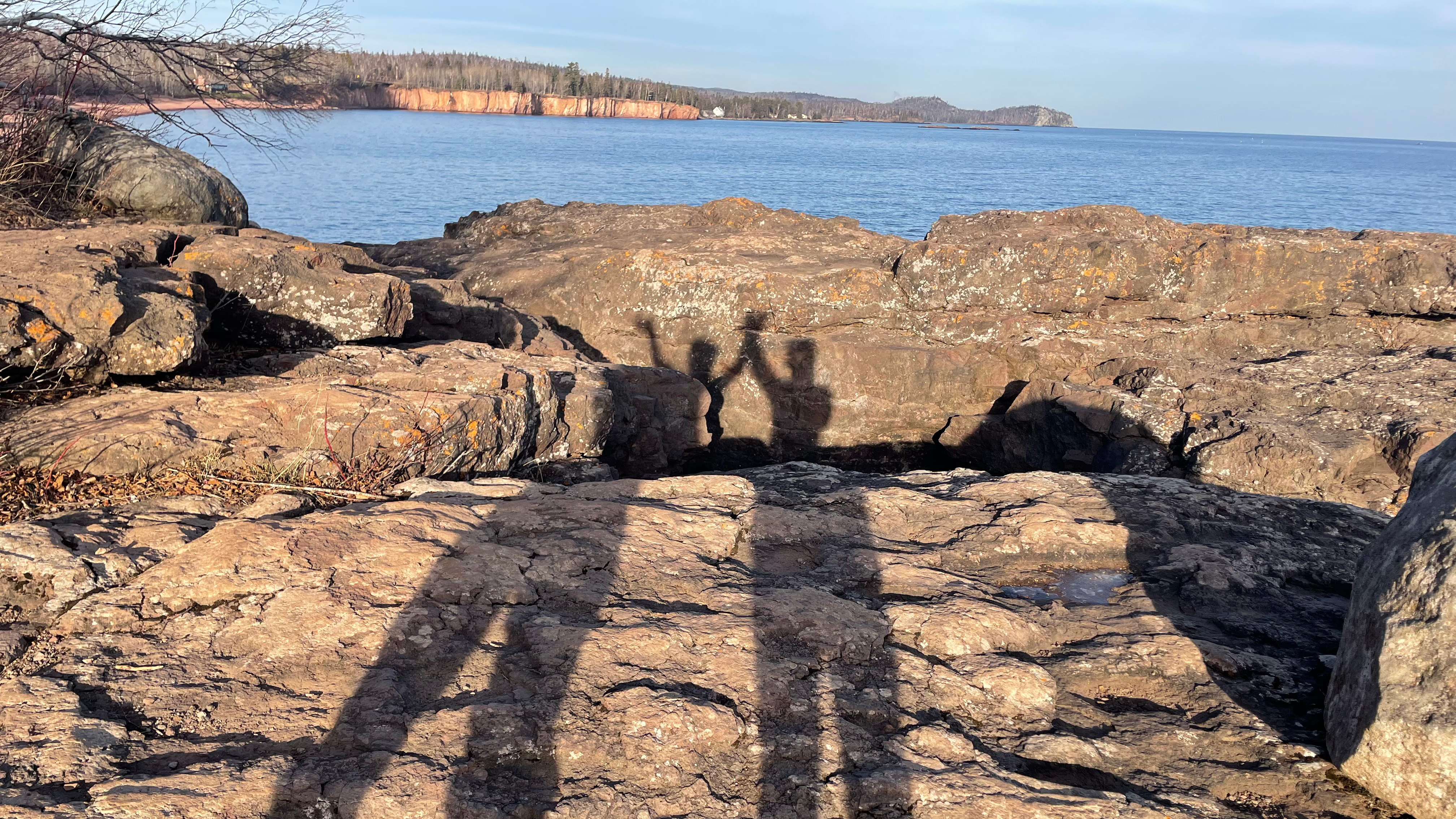 The shadows of two people waving.