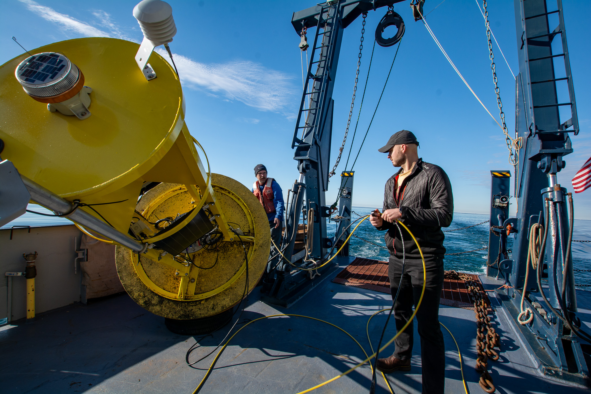 Jay Austin and members of his research team on R/V Blue Heron prep a meteorological buoy for deployment in western Lake Superior. 