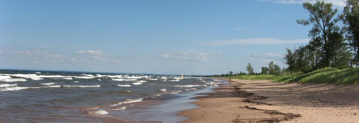 Sandy beach, lake with white capped waves