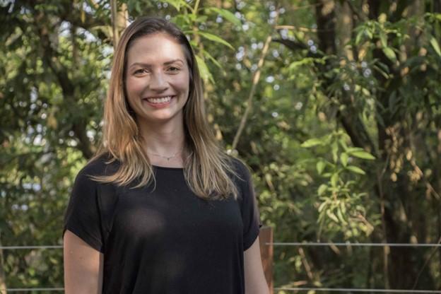 Maria Cristina de Almeida Silva smiling in front of a background of forest.