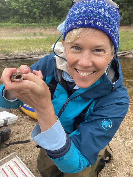 Amy Schrank holding a small Burbot fish in her hands.